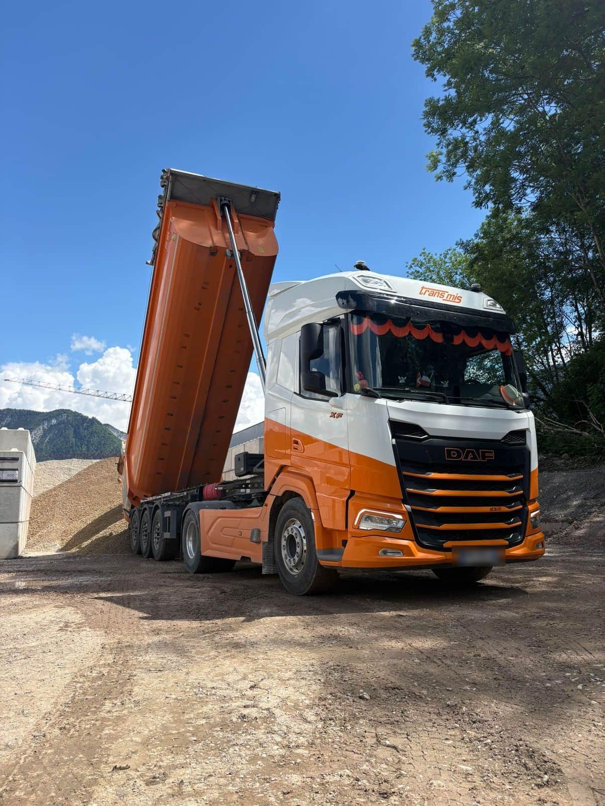 Semi-remorque benne TRANS MIS bennant des matériaux en cours de déchargement